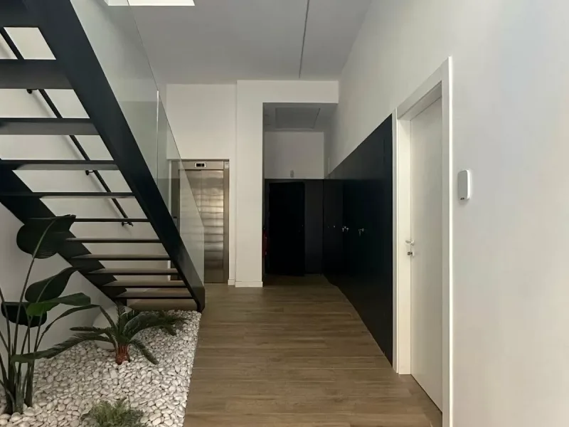 Portal de acceso del Edificio San Joaquín, con escalera y patio de guijarros